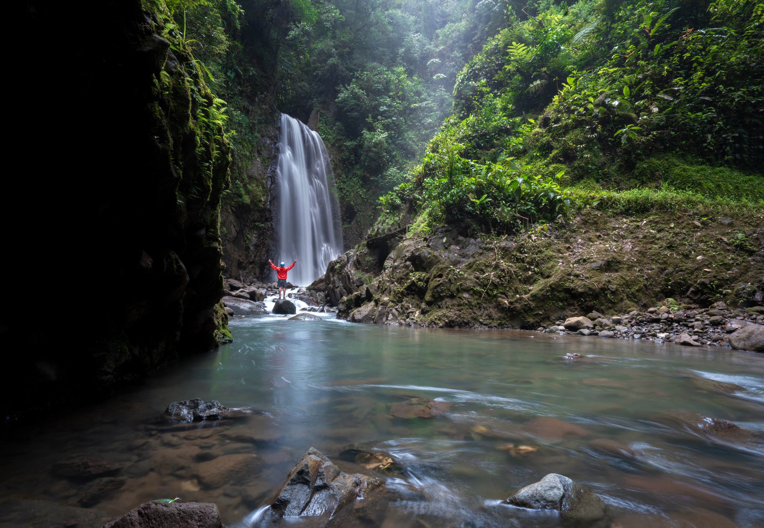 A person in red standing in front of one of El Tigre’s four waterfalls.